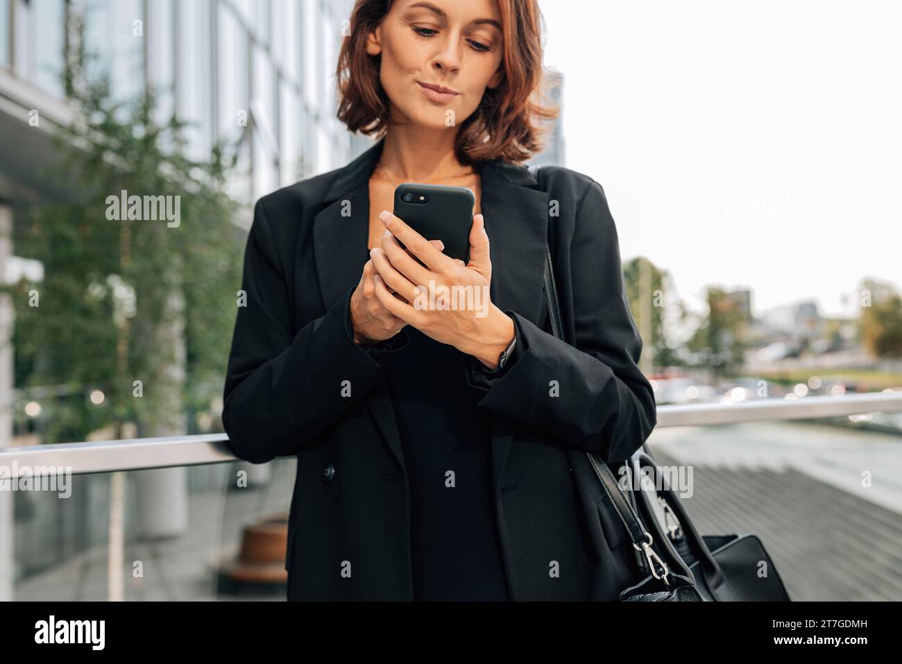 Nahaufnahme einer Geschäftsfrau mittleren Alters in formeller Kleidung mit Handy Stockfoto