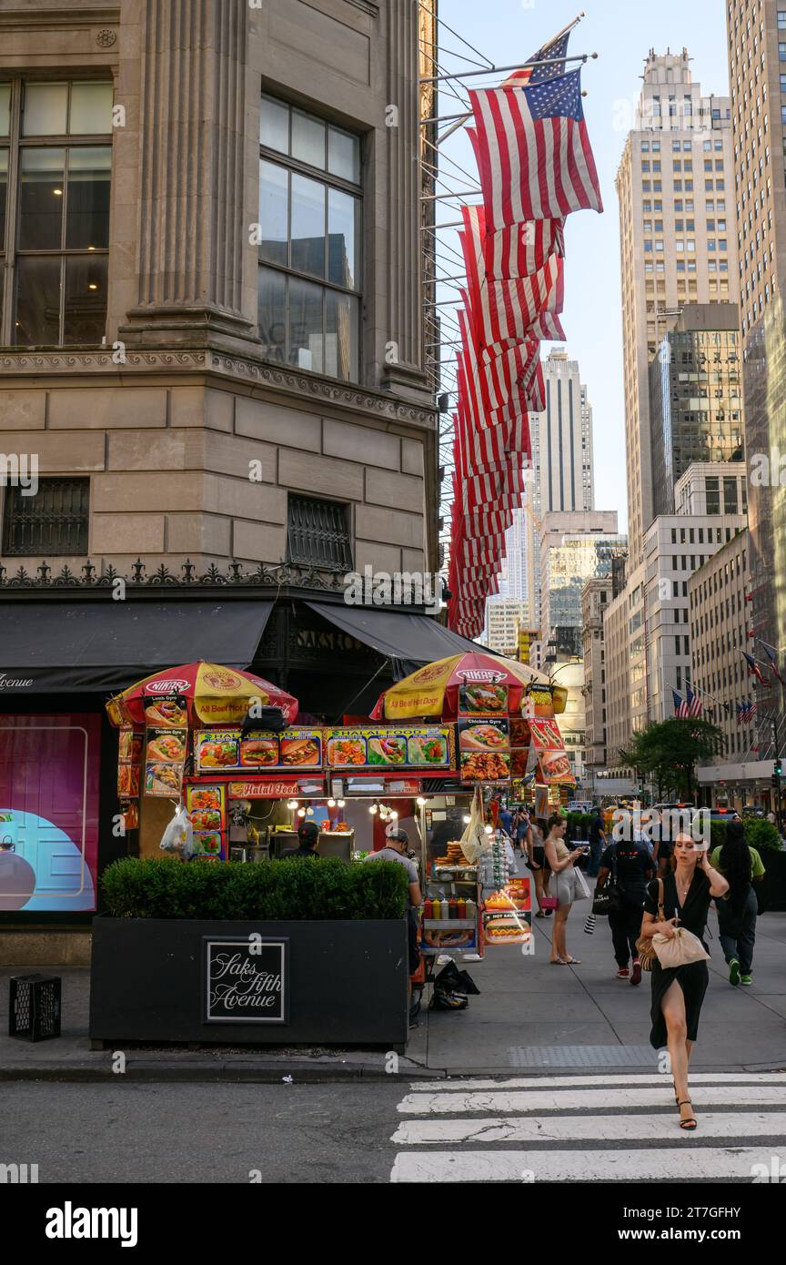 Eine Frau, die die Straße vor Saks auf der Fifth Avenue überquert Stockfoto
