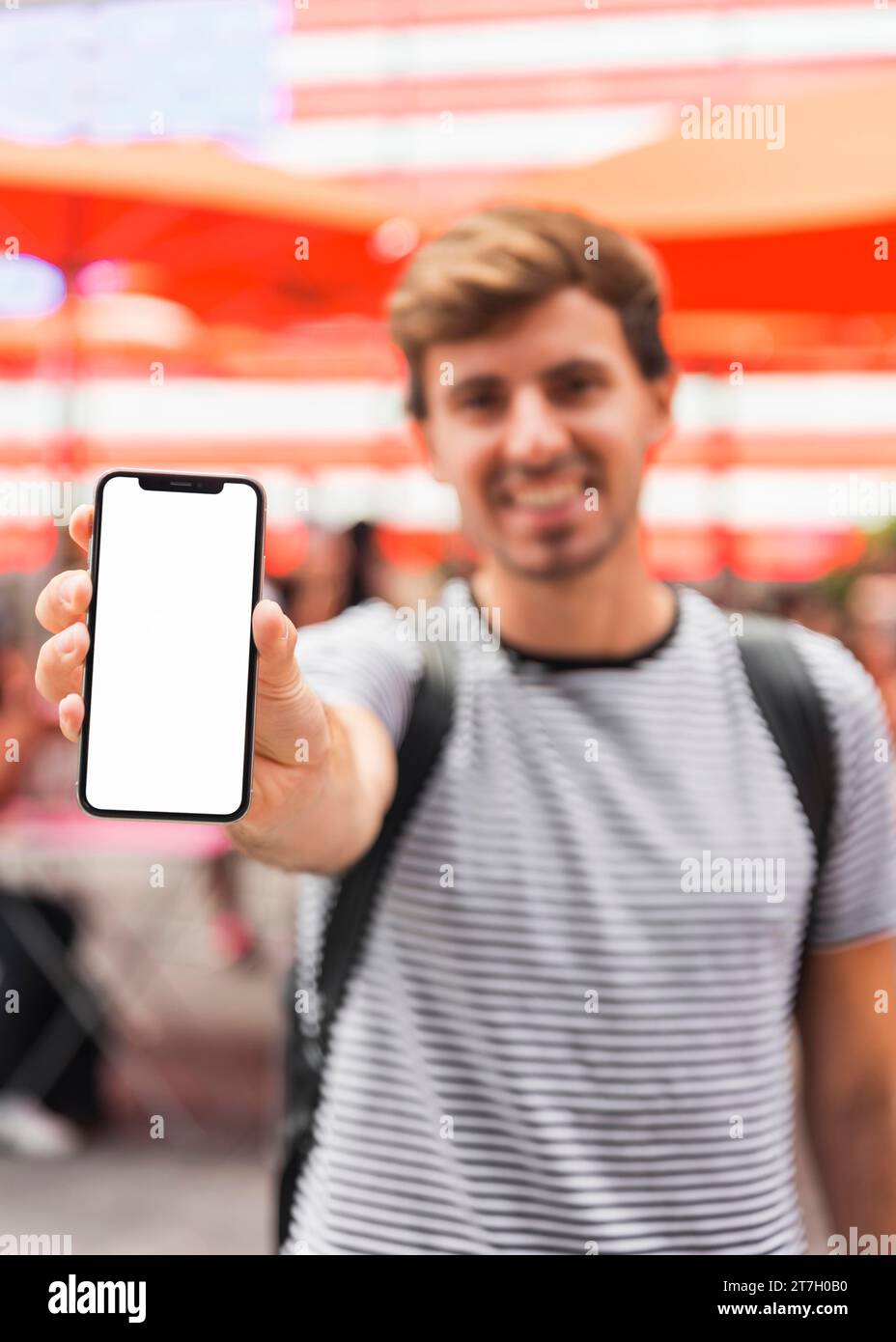 Junger Mann zeigt Smartphone-Bildschirm Stockfoto