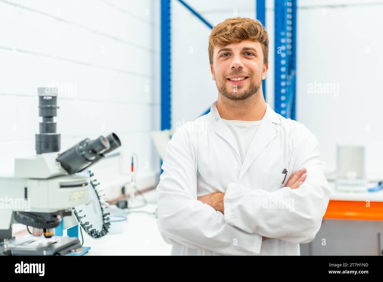 Porträt eines jungen Biologen, der mit überkreuzten Armen in einem Labor steht Stockfoto