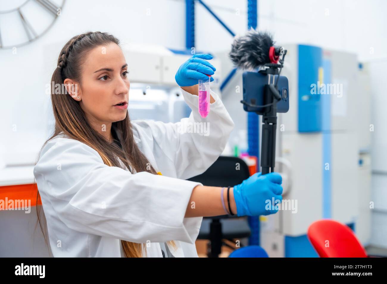 Wissenschaftler zeigen Proben, während sie ein Video aufnehmen, während sie ein mobiles Gerät im Labor aufnimmt Stockfoto