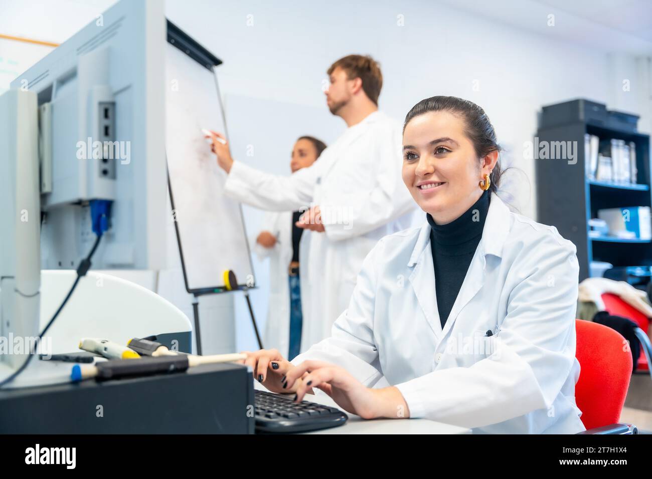 Lächelnder Nachwuchswissenschaftler am Computer im Labor Stockfoto