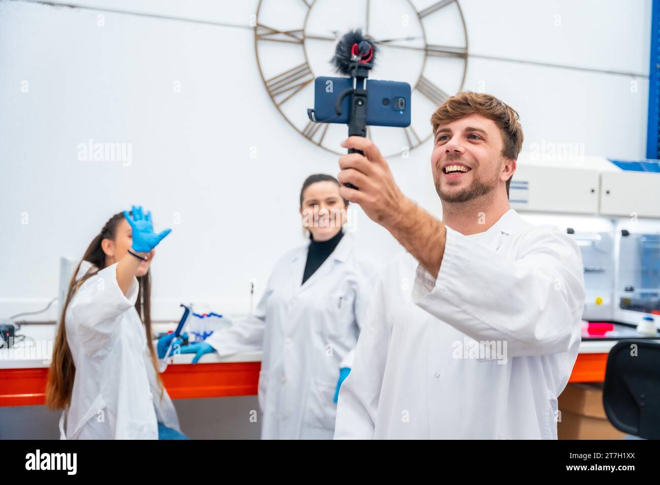 Ein Team von Wissenschaftlern nimmt ein Video mit einem Telefon in einem Labor auf Stockfoto