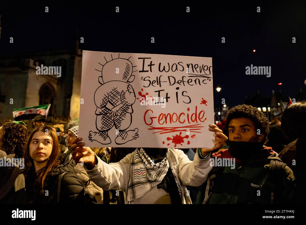 London, Großbritannien. November 2023. Ein Demonstrant hält ein Schild, während er vor dem britischen Parlament in Westminster demonstriert. Palästinensische Anhänger versammeln sich heute Abend vor dem Parlamentsplatz, während die Parlamentsabgeordneten über die Änderung des Waffenstillstands aus der Rede des Königs abstimmen, die von der Scottish National Party (SNP) vorgeschlagen wurde. Sie fordern einen sofortigen Waffenstillstand und die Eindämmung der Bombardements und der unschuldigen Tötung von Palästinensern, die von israelischen Truppen in Gaza gefangen sind. Quelle: SOPA Images Limited/Alamy Live News Stockfoto