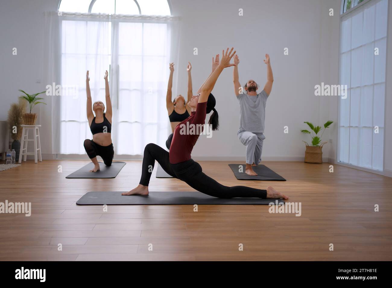 Eine Gruppe von Menschen spielt Yoga. Yoga, Bewegung und Gesundheitskonzept. Stockfoto