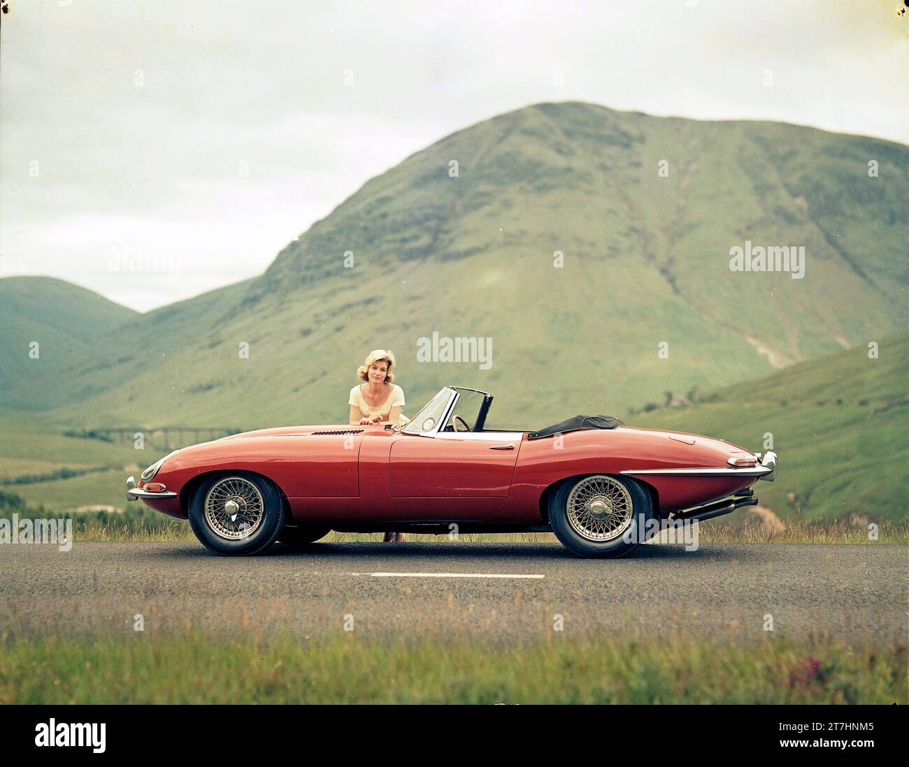 1961 Jaguar E-TYPE Serie 1 Roadster in Scottish Highlands mit weiblichem Modell Stockfoto