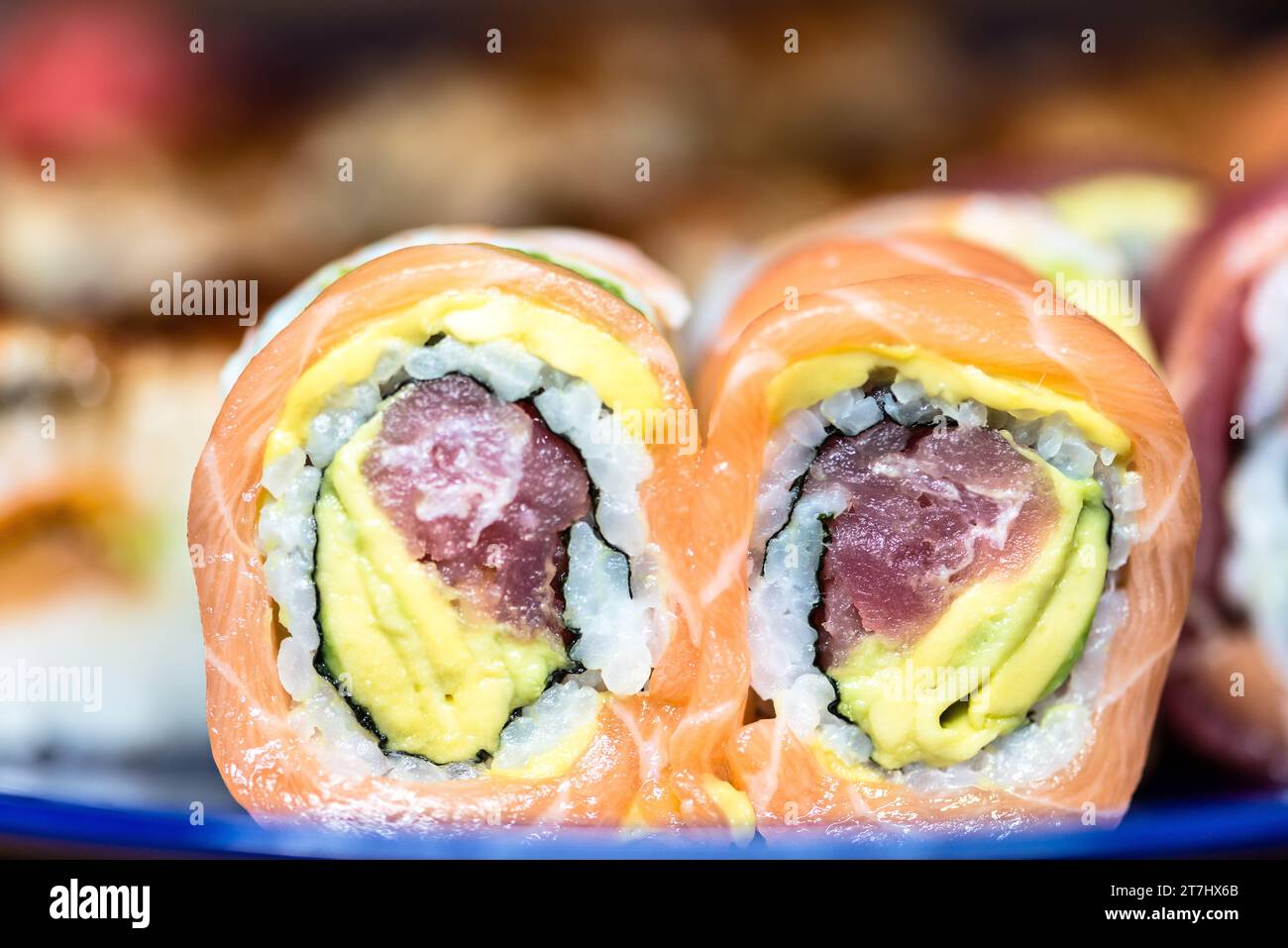 Ein Teller mit frisch zubereiteten Sushi-Brötchen mit cremiger Avocado Stockfoto