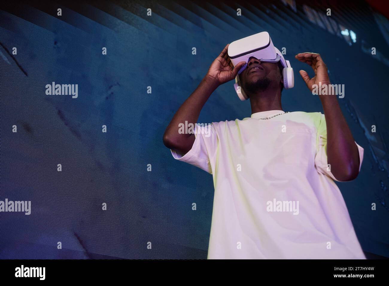 Futuristisches Porträt des jungen Schwarzen Mannes mit VR-Headset gegen Betonwand, Kopierraum Stockfoto