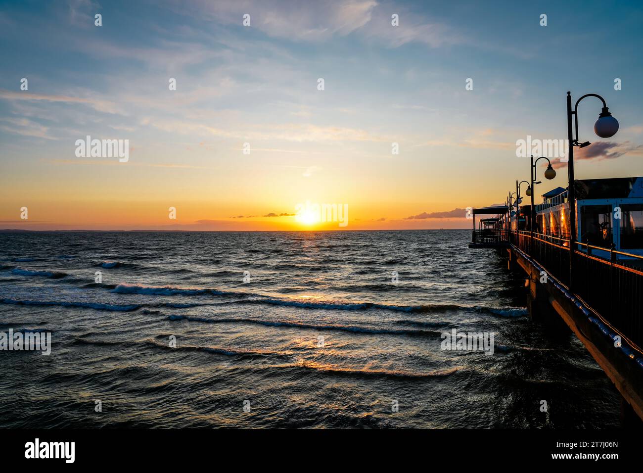 Pier am Strand in der Nähe von Misdroy in Polen. Natürlicher Küstenabschnitt an der polnischen Ostsee. Landschaft am Meer mit Sonnenuntergang am Pier. Stockfoto