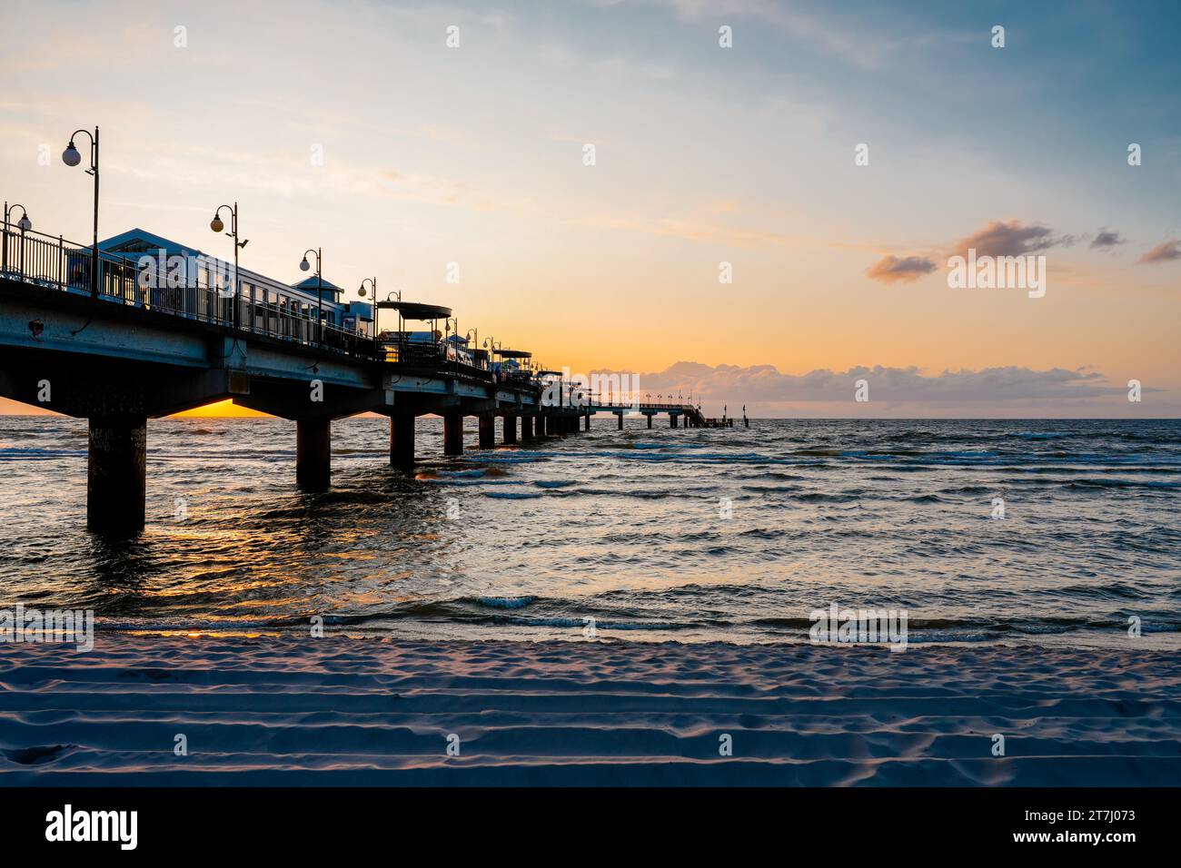 Pier am Strand in der Nähe von Misdroy in Polen. Natürlicher Küstenabschnitt an der polnischen Ostsee. Landschaft am Meer mit Sonnenuntergang am Pier. Stockfoto