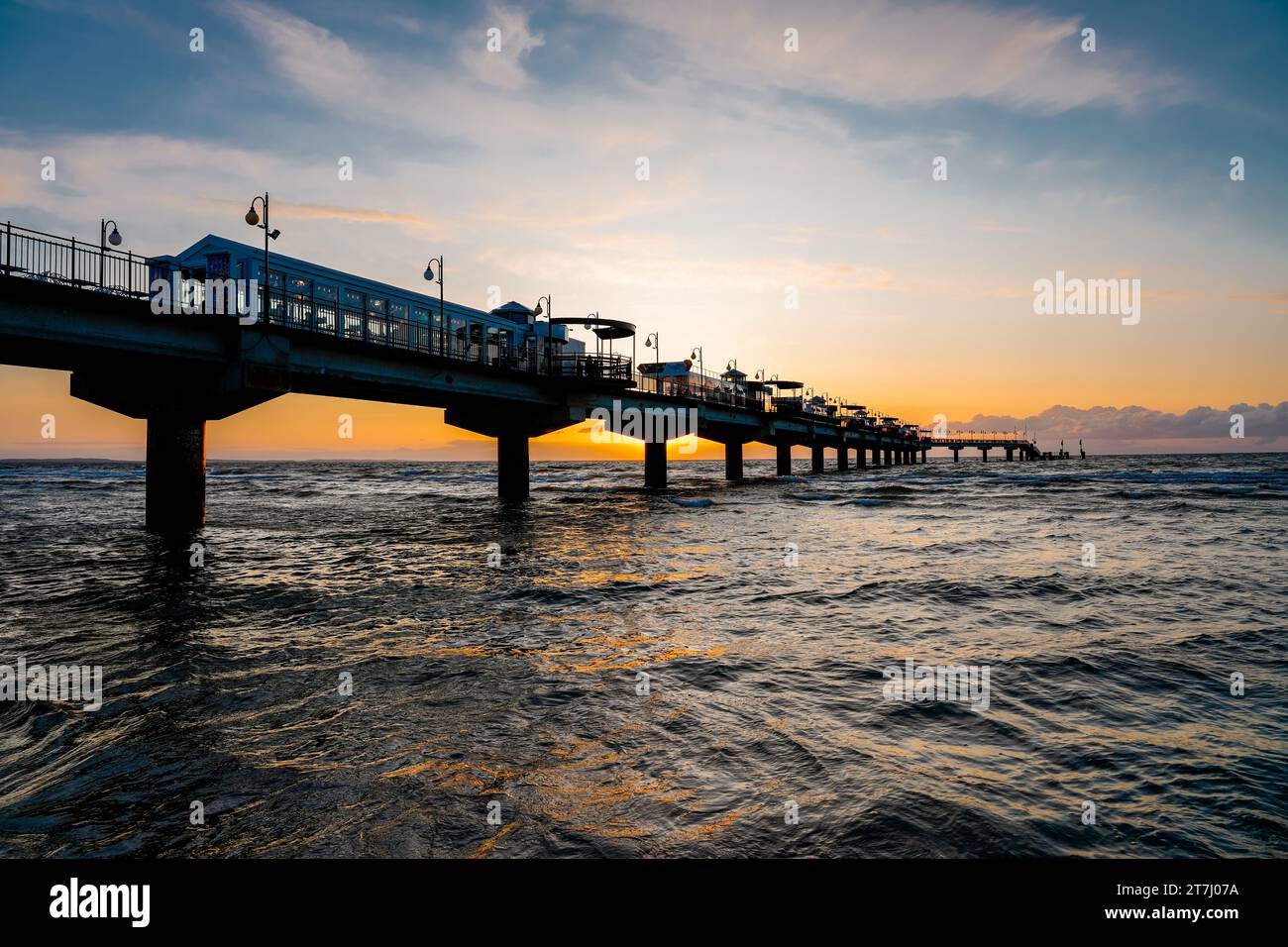 Pier am Strand in der Nähe von Misdroy in Polen. Natürlicher Küstenabschnitt an der polnischen Ostsee. Landschaft am Meer mit Sonnenuntergang am Pier. Stockfoto