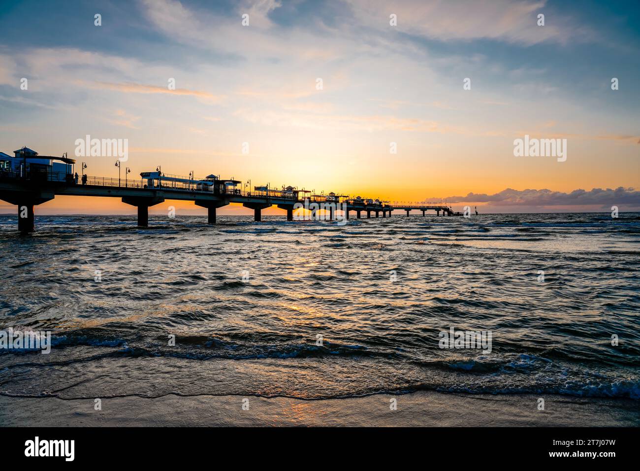 Pier am Strand in der Nähe von Misdroy in Polen. Natürlicher Küstenabschnitt an der polnischen Ostsee. Landschaft am Meer mit Sonnenuntergang am Pier. Stockfoto