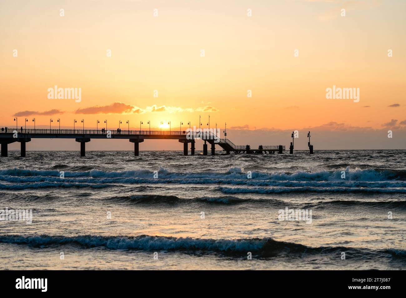 Pier am Strand in der Nähe von Misdroy in Polen. Natürlicher Küstenabschnitt an der polnischen Ostsee. Landschaft am Meer mit Sonnenuntergang am Pier. Stockfoto