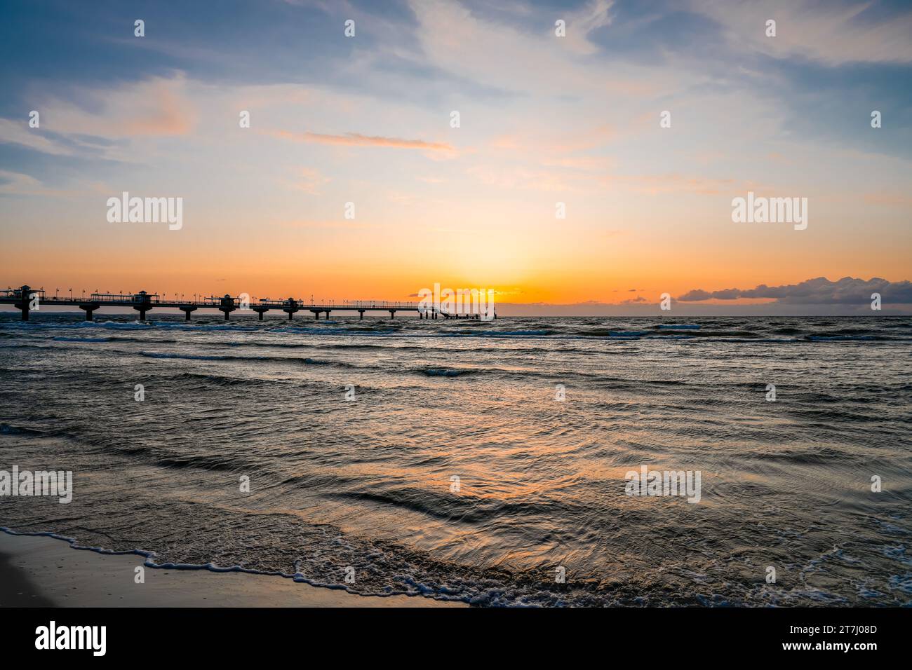 Pier am Strand in der Nähe von Misdroy in Polen. Natürlicher Küstenabschnitt an der polnischen Ostsee. Landschaft am Meer mit Sonnenuntergang am Pier. Stockfoto