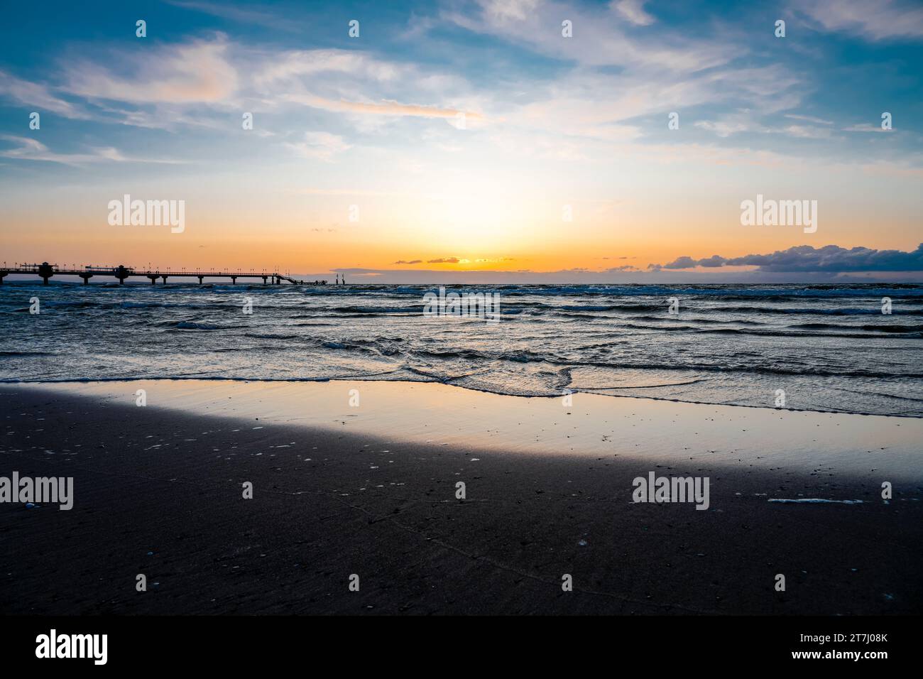 Pier am Strand in der Nähe von Misdroy in Polen. Natürlicher Küstenabschnitt an der polnischen Ostsee. Landschaft am Meer mit Sonnenuntergang am Pier. Stockfoto