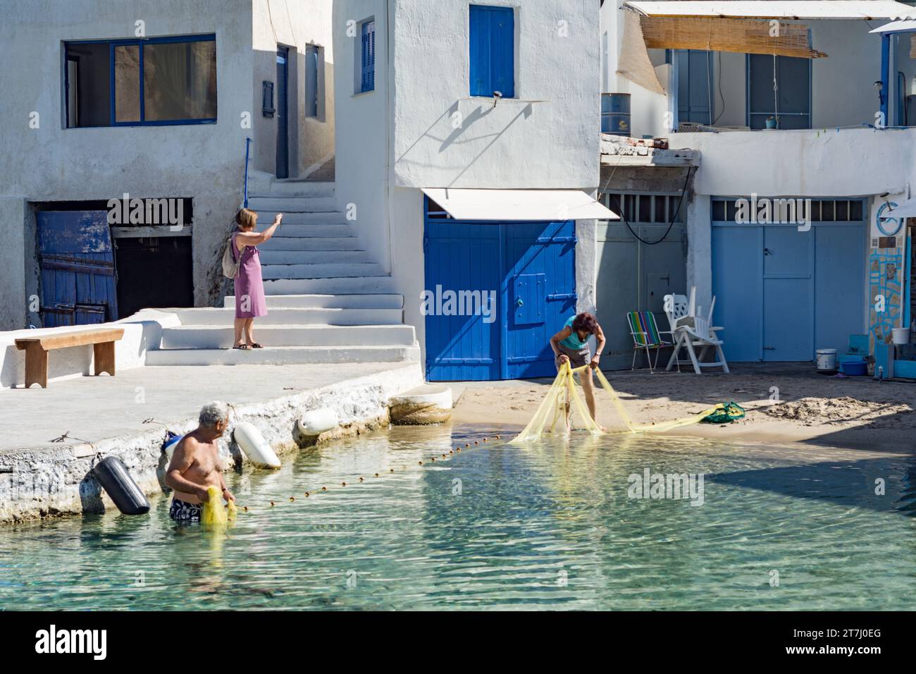 Leute, die Fischernetze in dem charakteristischen Dorf Firopotamos, Milos, aufstellen Stockfoto