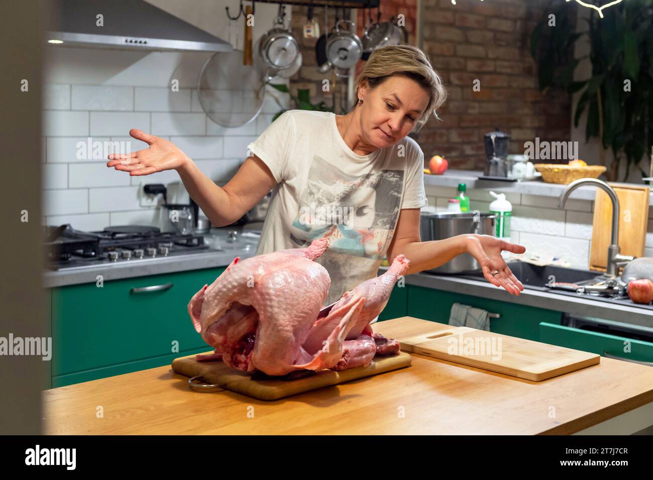 Frau mittleren Alters in der Küche, die großen truthahn für Thanksgiving-Dinner vorbereitet Stockfoto