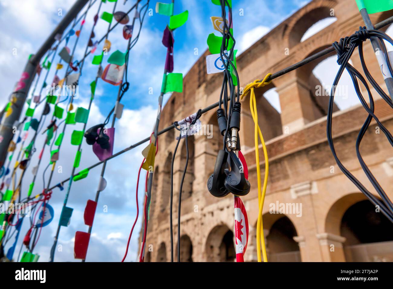 Entsorgte Kopfhörer, die von Touristen an einem Zaun vor dem Kolosseum in Rom, Italien benutzt wurden Stockfoto