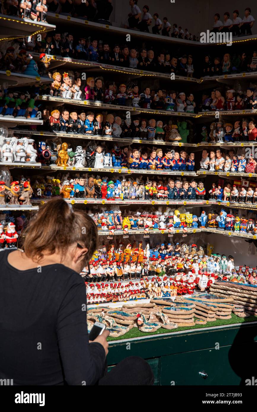 Santa Llucia Market Vibes: Ein belebter Stand mit festlichen Caganer-Figuren, die das Wesen der Weihnachtstradition Barcelonas festhalten. In der Nähe, A Stockfoto