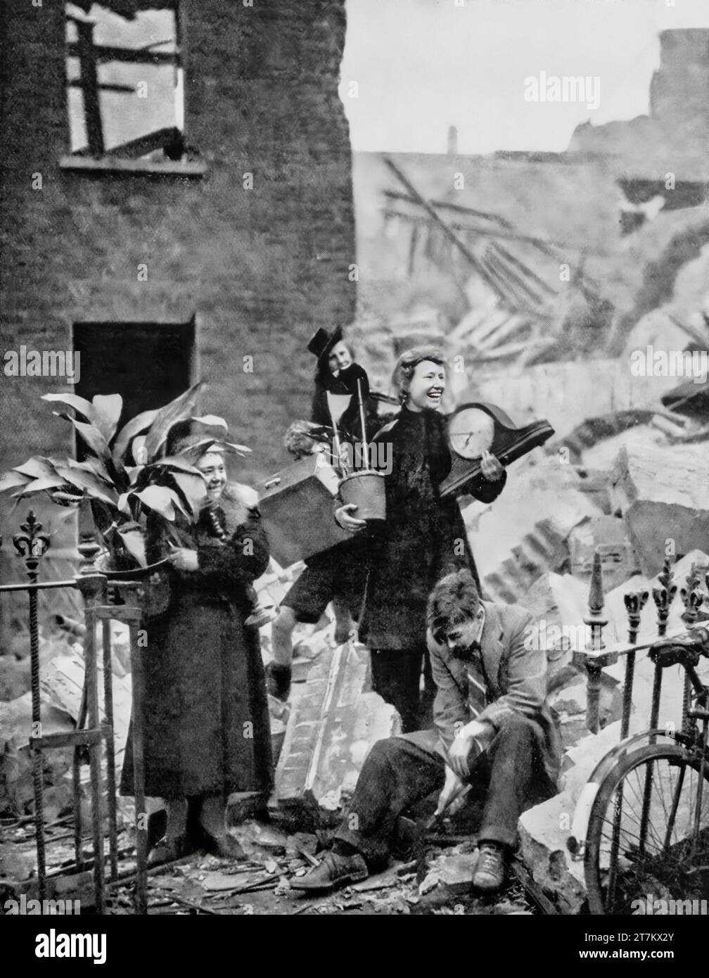 Trotz schlafloser Nächte während des Zweiten Weltkriegs in Luftschutzbunker schaffen es Londoner immer noch zu lächeln, nachdem sie eine Uhr und eine Aspidestra aus ihrem kürzlich bombardierten Haus, London, England, im Oktober 1940 gerettet haben. Stockfoto