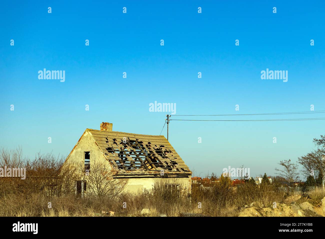 Altes, verfallenes verlassenes Haus auf leerem Grundstück. Privathaus mit einem zerstörten Dach. Stockfoto