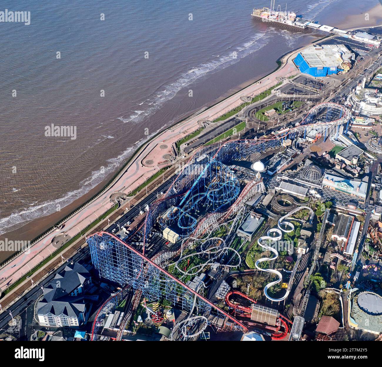 Ein Luftbild der Strandfront und des Strandes in Blackpool, Nordwestengland, Großbritannien und der Pleasure Beach Fun Fair und Fahrgeschäfte Stockfoto