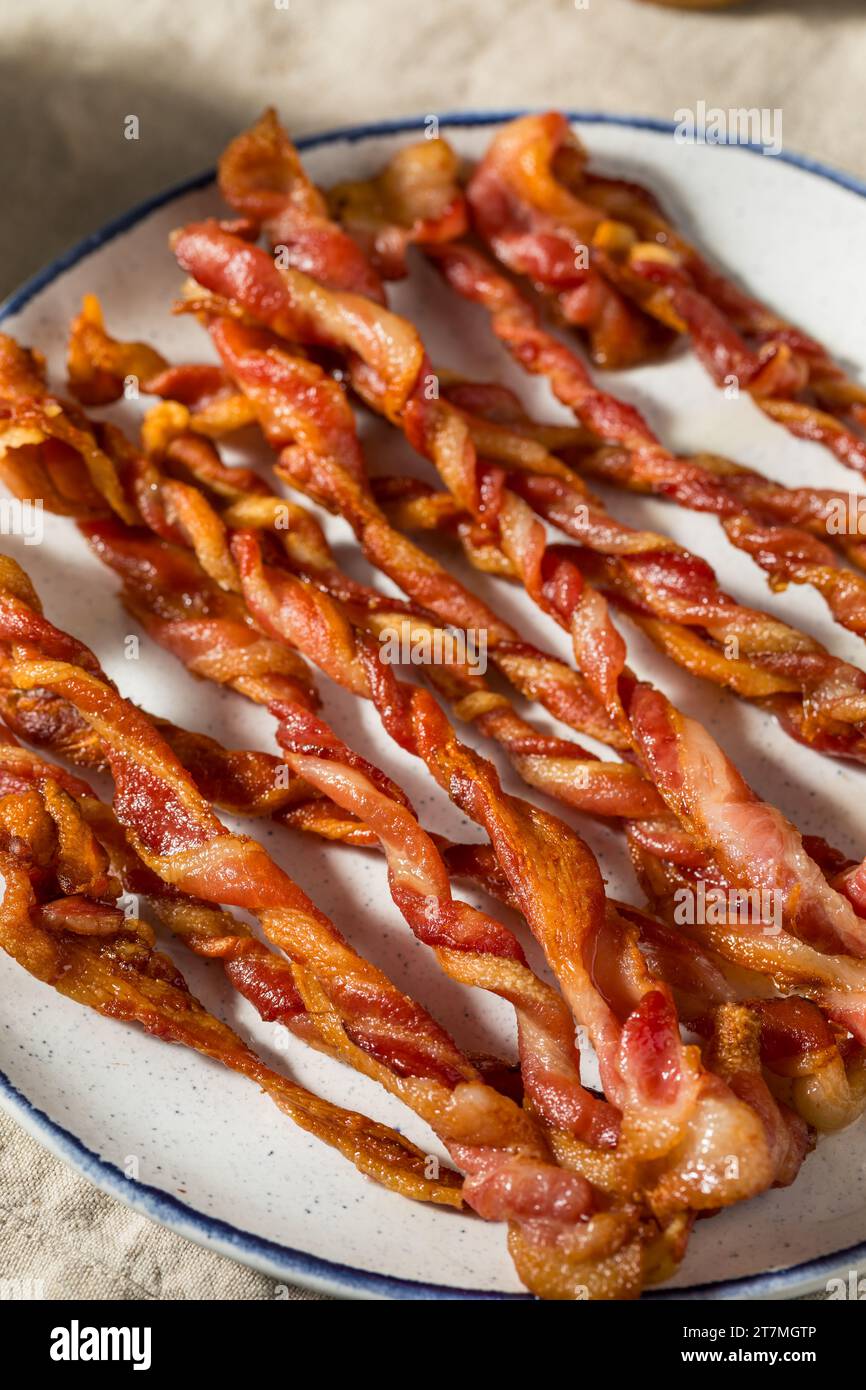 Hausgemachte trendige Twisted Bacon Strips auf einem Teller Stockfoto