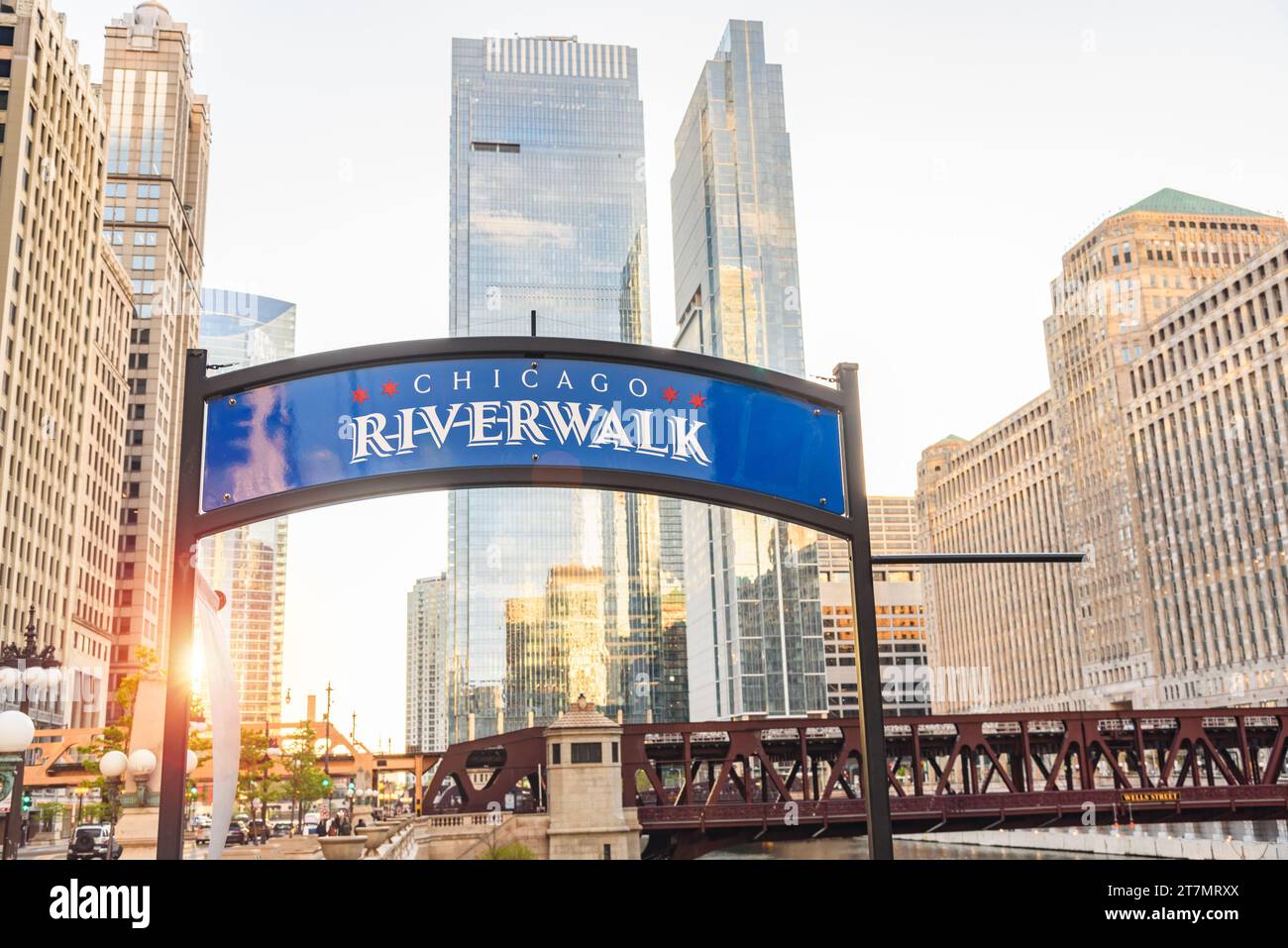 Chicago Riverwalk Schild mit Wolkenkratzern im Hintergrund bei Sonnenuntergang Stockfoto