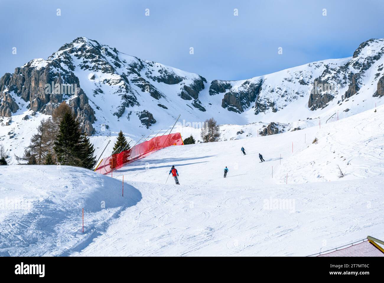 Skifahrer auf einer hochgelegenen Skipiste in einem Alipne-Skigebiet an sonnigen Wintertagen Stockfoto