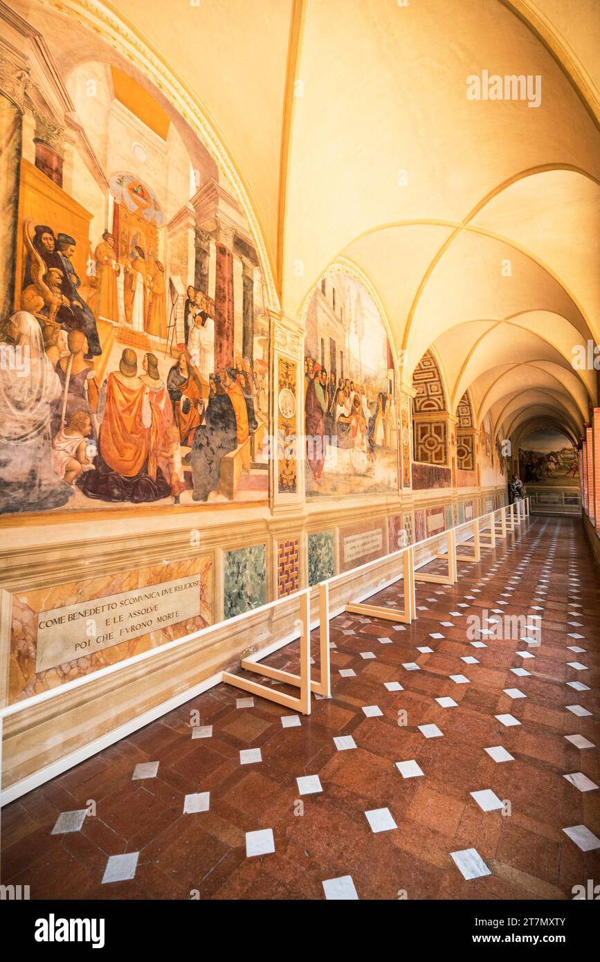 Asciano, Italien -: Touristen spazieren vorbei am Leben der Fresken des Heiligen Benedikt, gemalt von Giovanni Antonio Bazzi (Sodoma) in den späten 1400er Jahren Stockfoto