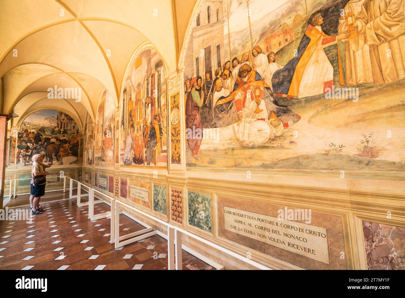 Asciano, Italien - Touristen gehen am Leben der von Giovanni Antonio Bazzi (Sodoma) in den späten 1400ern gemalten St. Benedict-Freskos vorbei Stockfoto