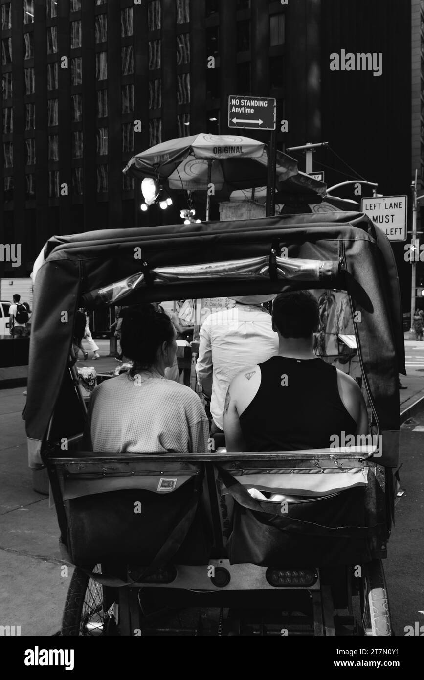 Ein Paar, das in einem Pedikab durch Manhattan in New York City reitet Stockfoto