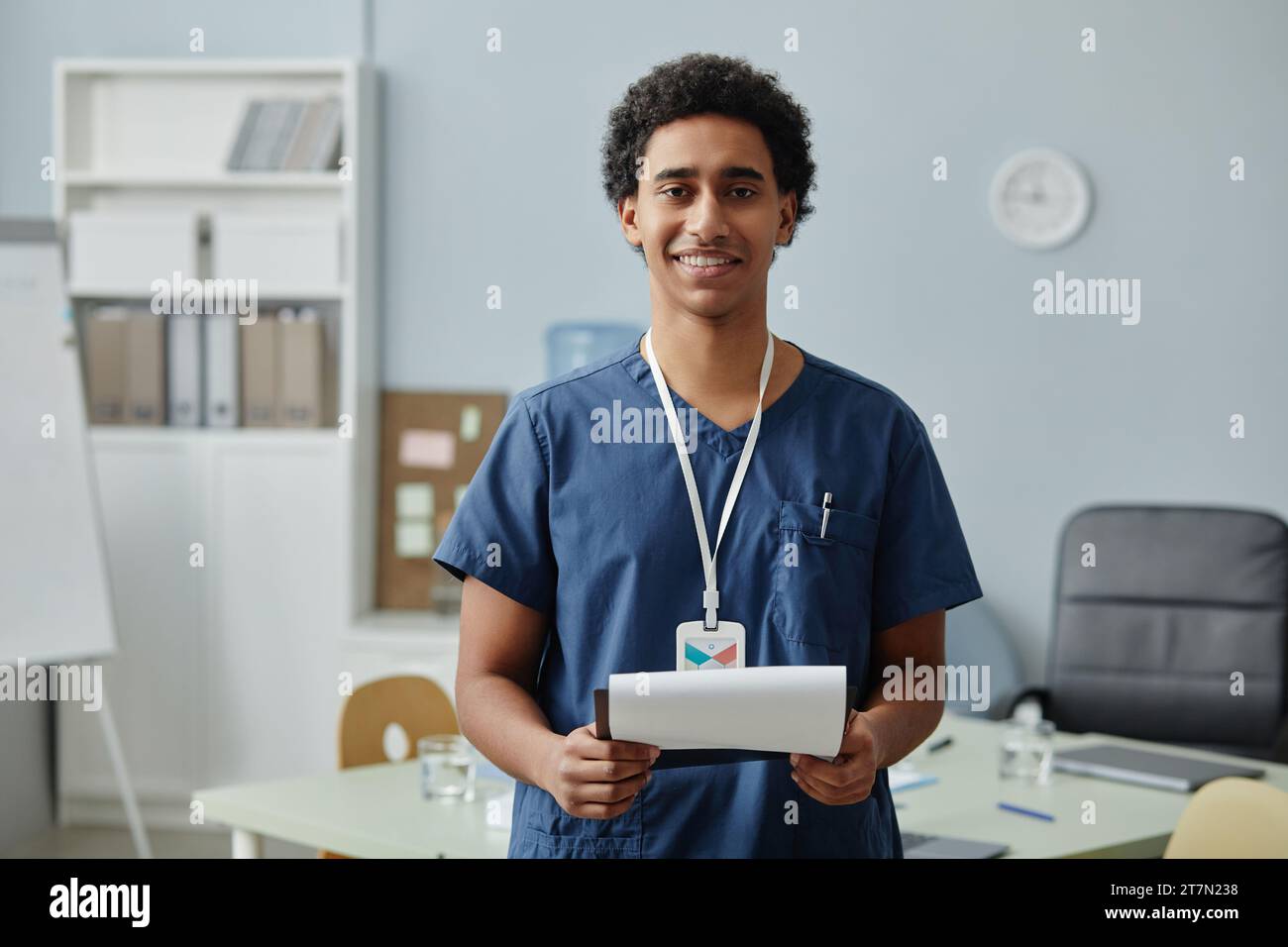 Porträt eines jungen arabischen Mannes, der in Uniform schrubbt und in der Klinik ein Klemmbrett hält, Kopierraum Stockfoto