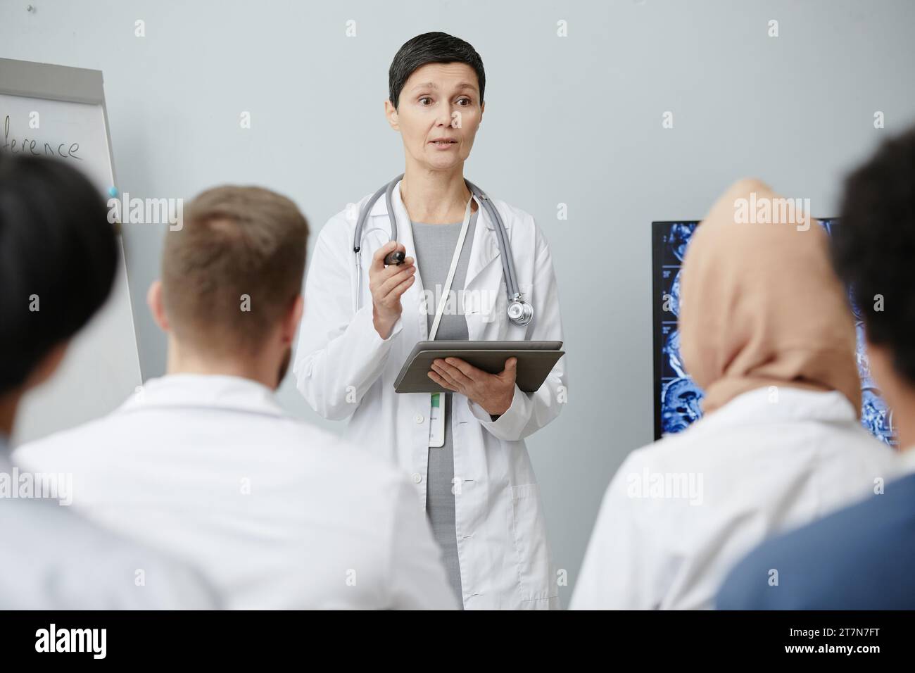 Taille hoch Porträt der Reifen Ärztin, die mit Publikum auf dem medizinischen Seminar spricht, Kopierraum Stockfoto