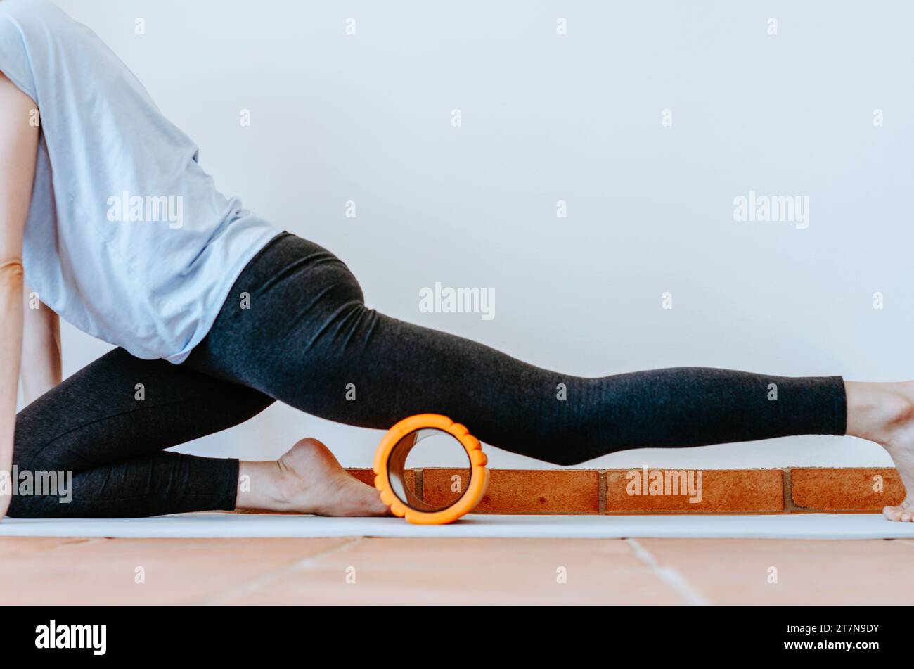 Quadrizeps-Selbstmyofaszienfreisetzung mit Schaumwalze Stockfoto