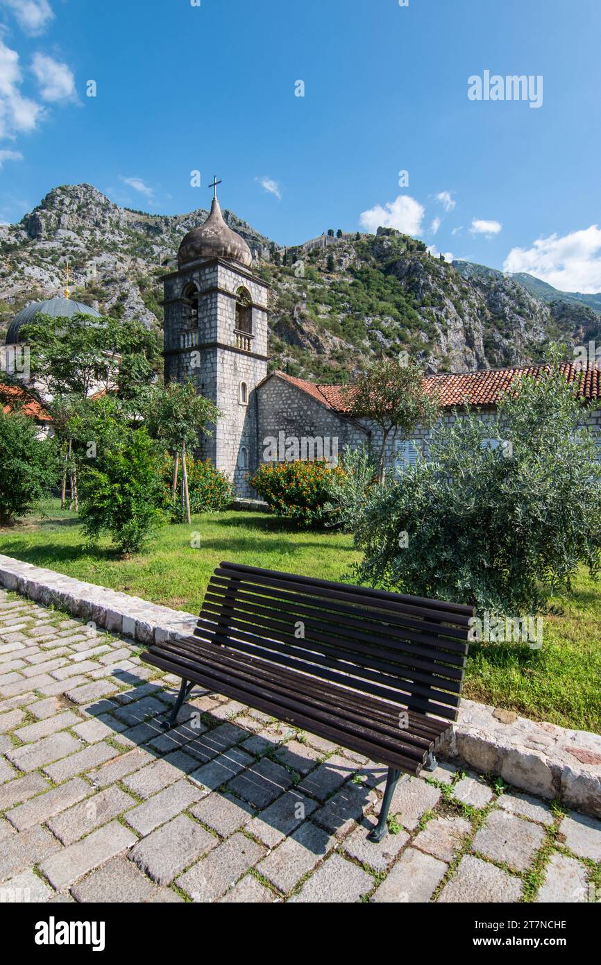 Bank vor dem Glockenturm der Kirche Saint Clare in der Altstadt von Kotor, Montenegro. Stockfoto