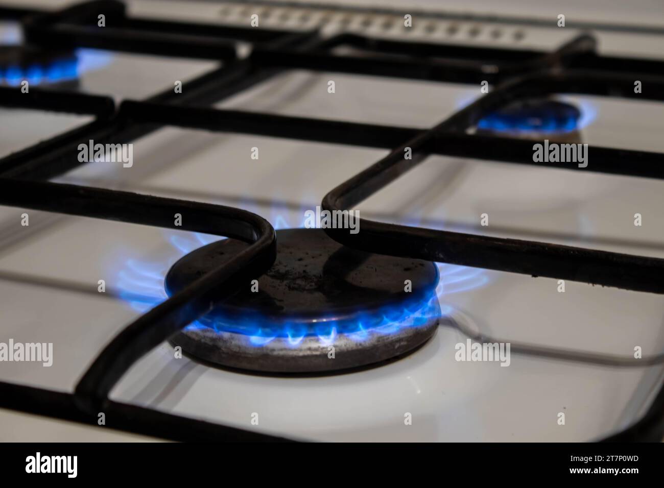 Closeup Schuß von Blue Fire aus heimischer Küche Herd. Gasherd mit brennenden Flammen von Propangas. Industrie und Wirtschaft Konzept. Stockfoto