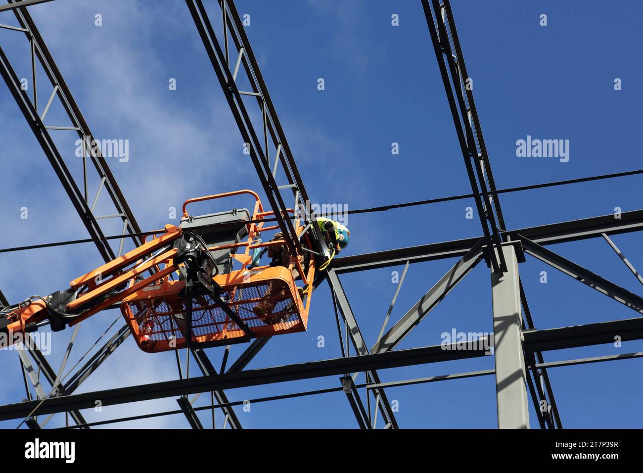 Ein Schweißer schweißt während des Baus eines Lagerhauses Dachträger aus Stahl Stockfoto