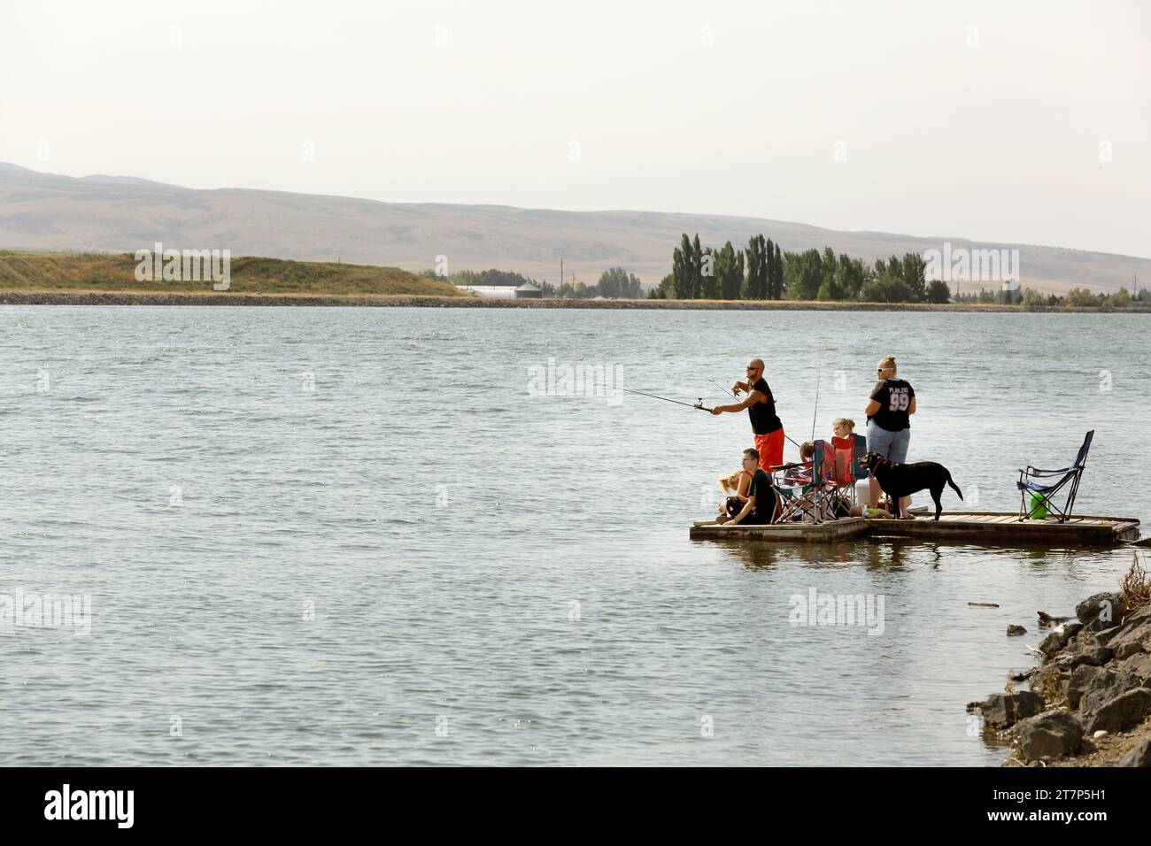 Eine Familie fischt von einem schwimmenden Dock am Gem Lake in Idaho Falls, Idaho. Stockfoto