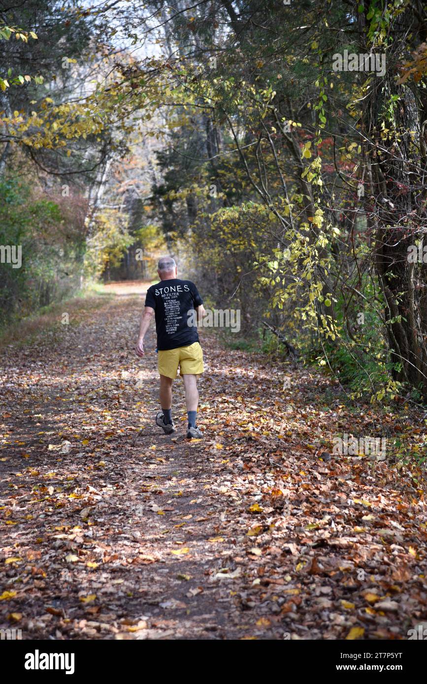 Ein älterer Mann, der ein T-Shirt von der Rolling Stones No Filter Tour 2019 trägt, läuft entlang des Virginia Creeper Trail in Abingdon, Virginia Stockfoto