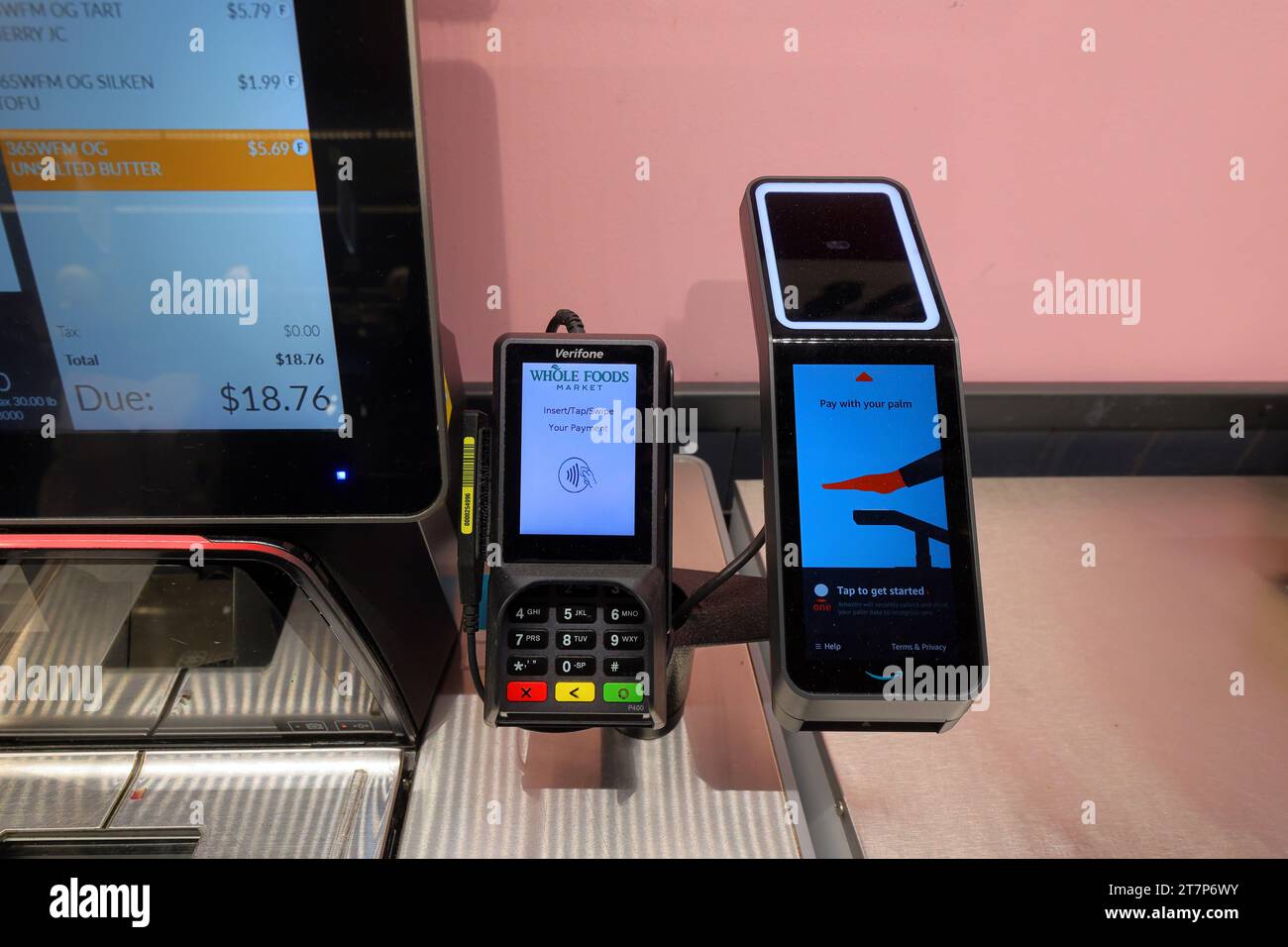 Ein Amazon One Palm-Bezahlgerät und ein kontaktloses Verifone Kreditkartenlesegerät an einer Self-Service-Kasse. Stockfoto