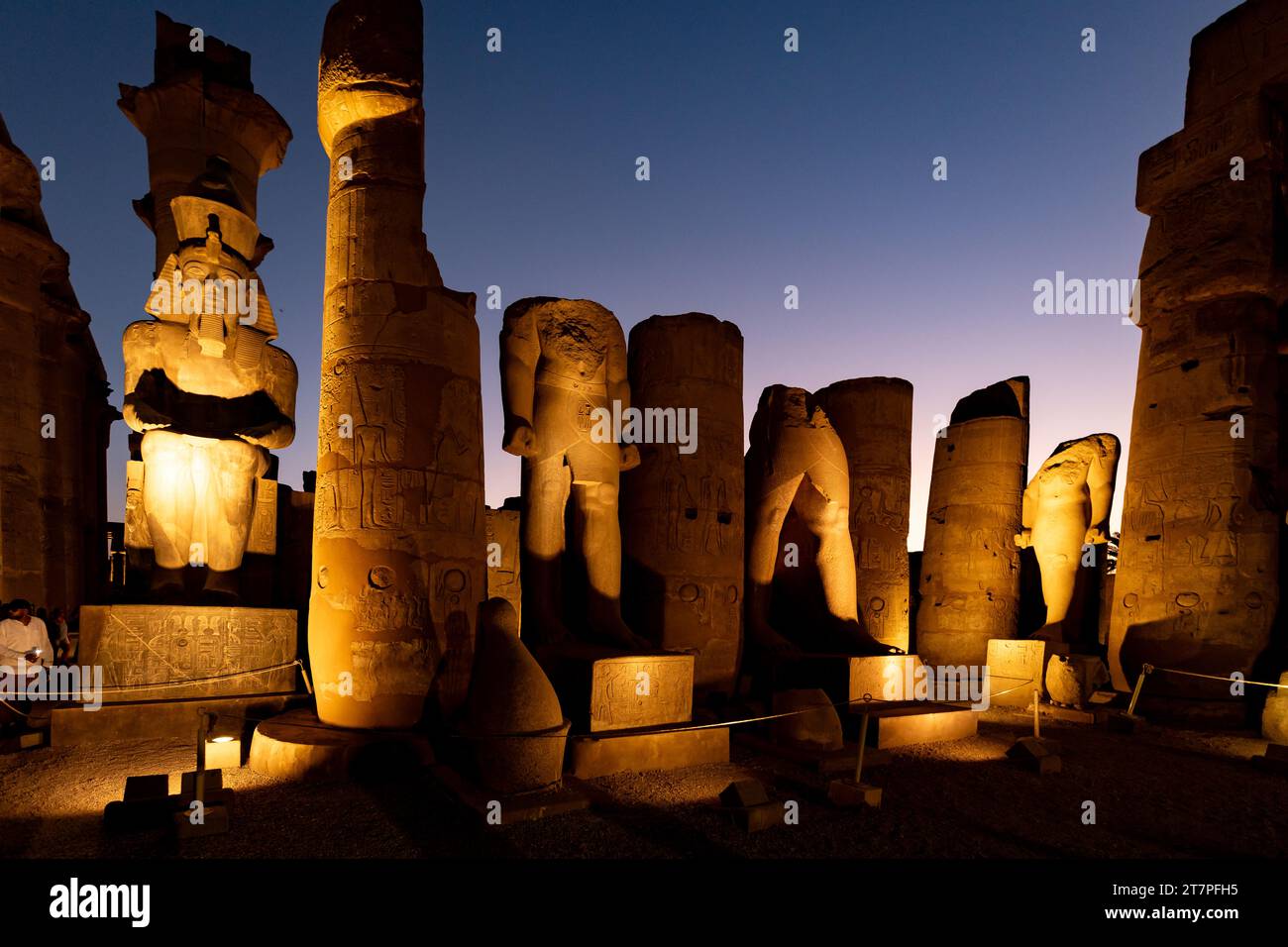 Nächtlicher Blick auf die Statuen Säulen und Hieroglyphen des archäologischen Schatzes und Touristenziel des Luxor-Tempels, beleuchtet bei Nacht Stockfoto