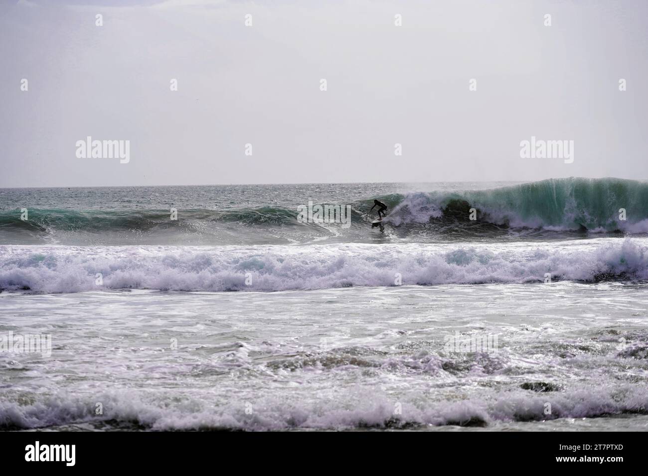 Surfer können am Strand in Praia do Burgau, Viertel Faro, Algarve, Portugal, surfen Stockfoto