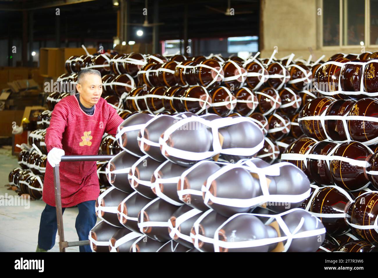 CHONGQING, CHINA – 16. NOVEMBER 2023 – Ein Arbeiter transportiert Keramikprodukte in einer Keramikwerkstatt in Chongqing, China, 16. November 2023. Stockfoto