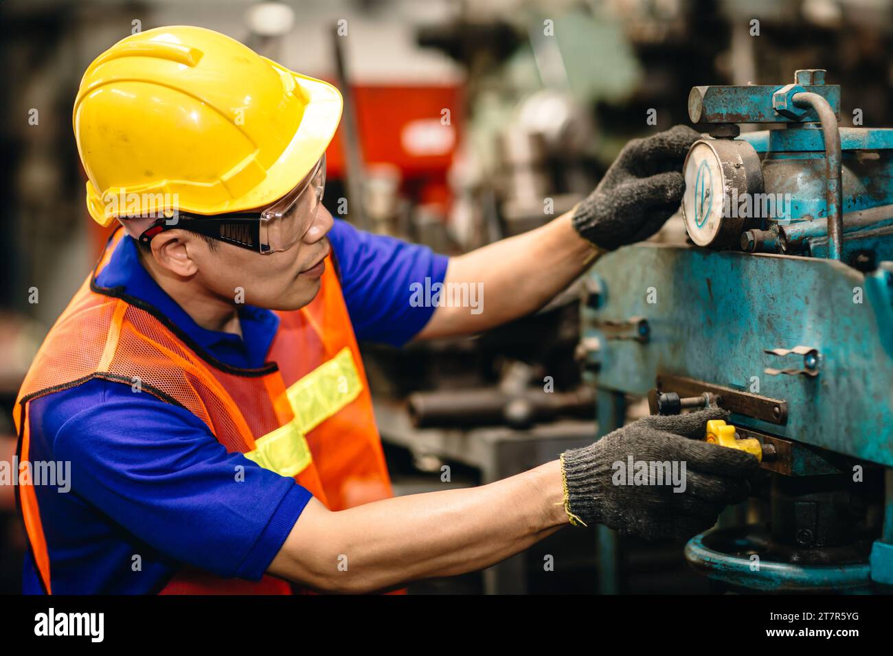 Ingenieur Frästechniker männlicher Arbeiter Asiatische chinesische manuelle Handfertigkeit, die in der Schwerindustrie Steuerungs-Metalldrehmaschine arbeitet Stockfoto