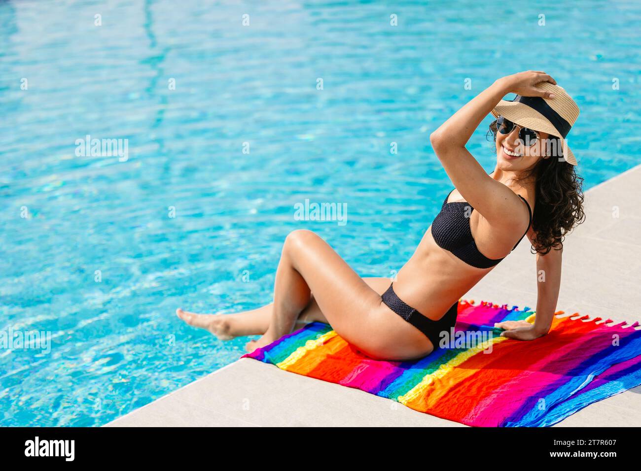 Porträt glücklich lächelnde Bikinifrau Genießen Sie Entspannung am Swimmingpool Sommerurlaub. Mädchen im Badeanzug genießen Sie den Urlaub am Pool in luxuriöser Stockfoto