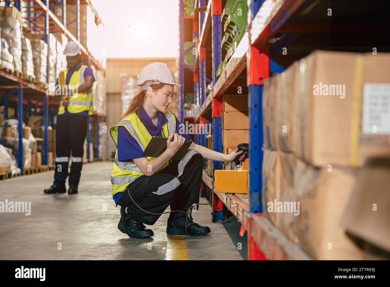 Lagerarbeiter. Lagerbestandsmitarbeiter Lagerbestandsmitarbeiter arbeiten im Ladungsregal und überprüfen den Versandauftrag mithilfe eines Tablets. Stockfoto