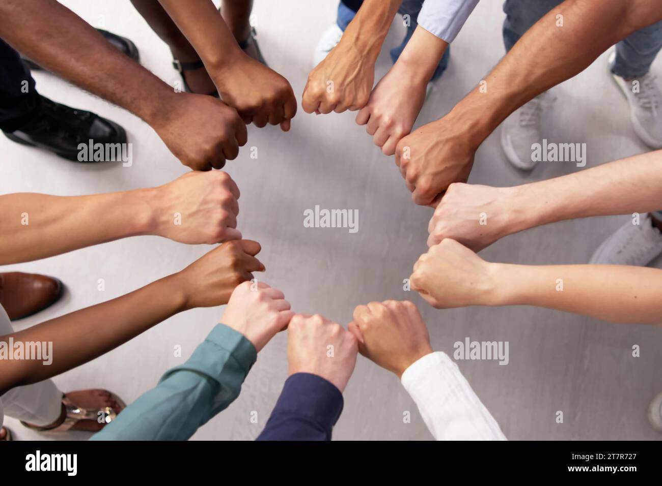 Multi-Ethnic-Team unterstützt Einheit mit Racial Fist Huddle Stockfoto