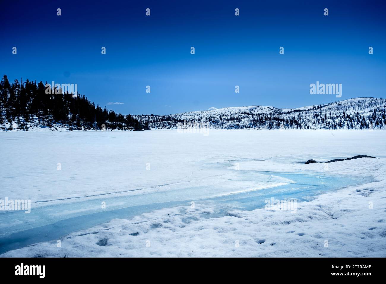 Gefrorener See mit schneebedeckten Bergen nach tiefem Schneefall im Winter Stockfoto