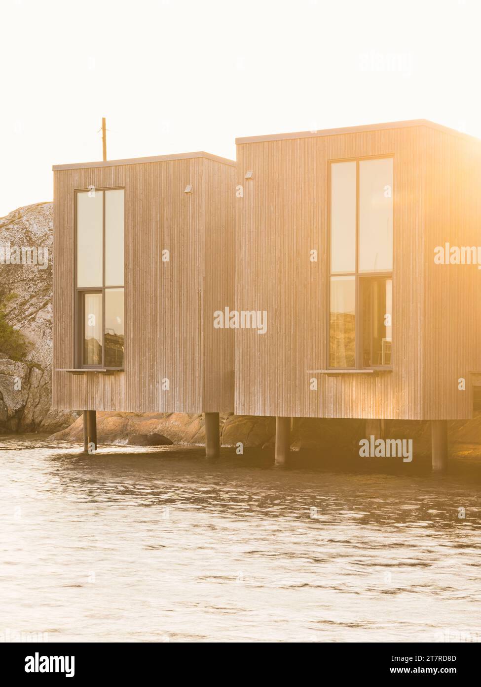 Modernes Gebäude am Wasser in Schweden mit Holzfassade und wunderschönem Sonnenuntergang. Stockfoto